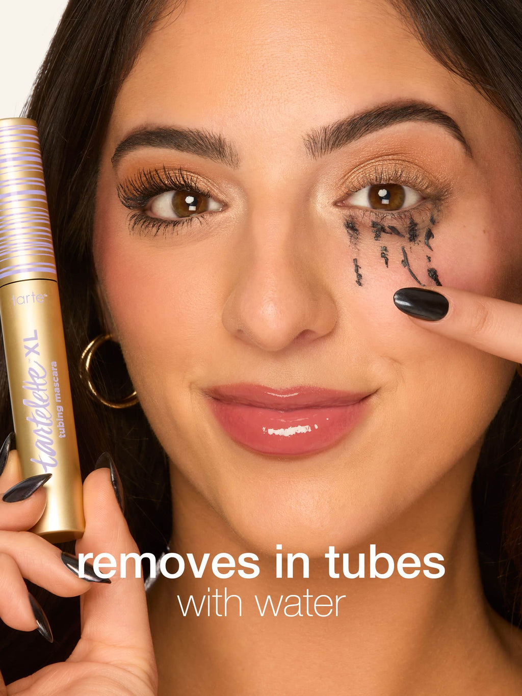 Woman applying makeup remover to her face with text tartelette tubing XL mascara 'removes in tubes with water' 