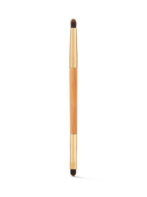 Makeup brush with wooden handle and black bristles on a white background