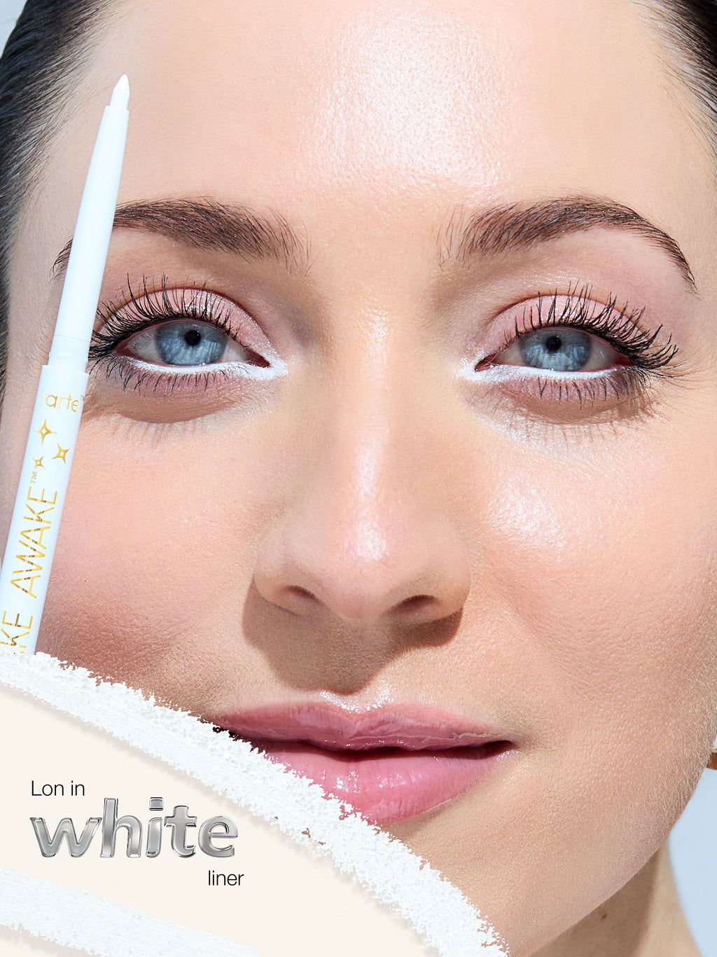 Close-up of a woman's face with a white eyeliner pencil labeled 'LON IN WHITE mascara' on a light background.
