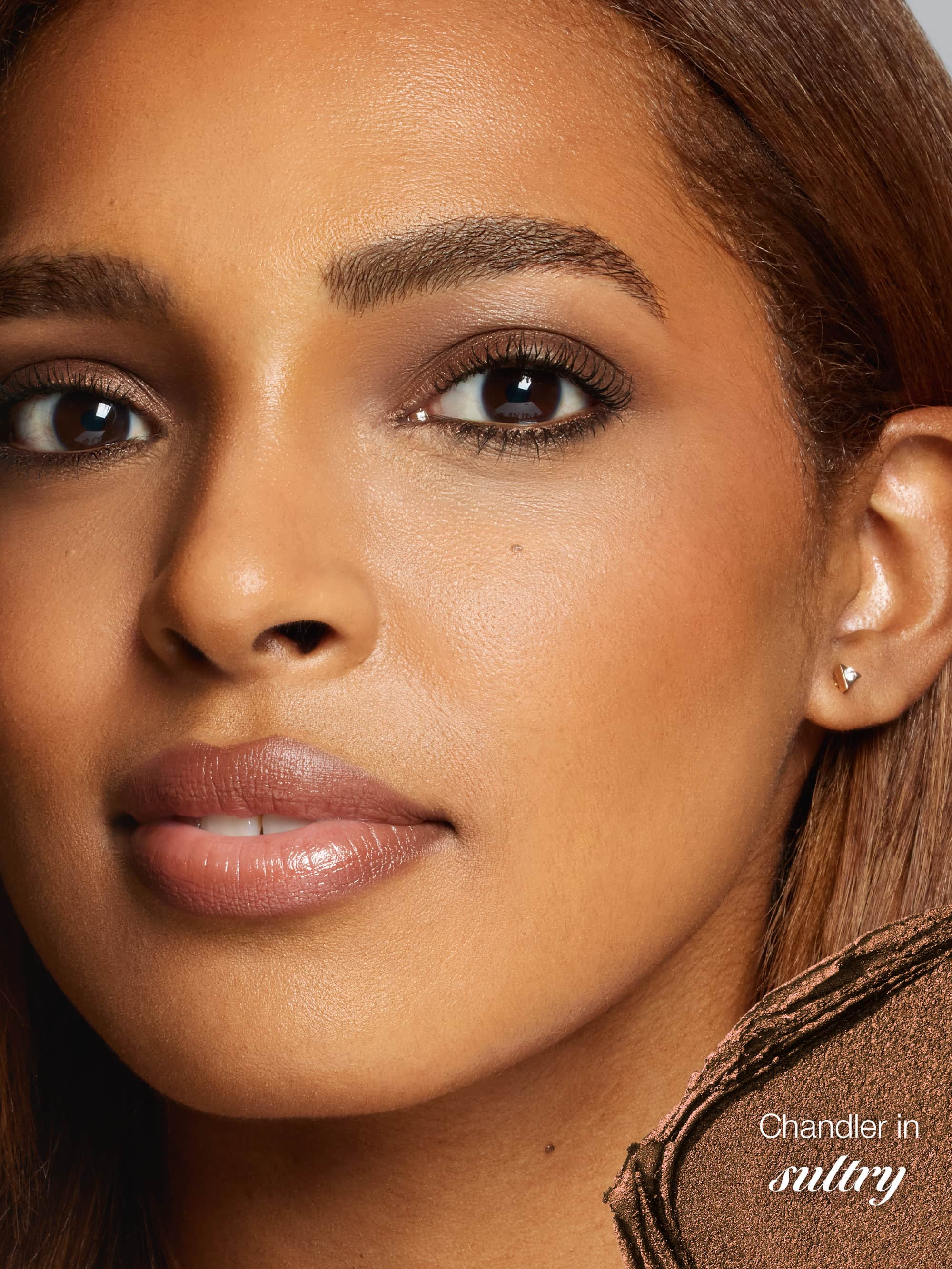 Close-up of a woman's face with a focus on her ear and hair, featuring the brand 'Chandler'.